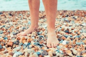THe feet of a young woman as she is standing on the beach